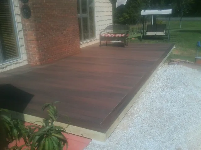 Freshly stained wood deck built against a brick home in Wichita