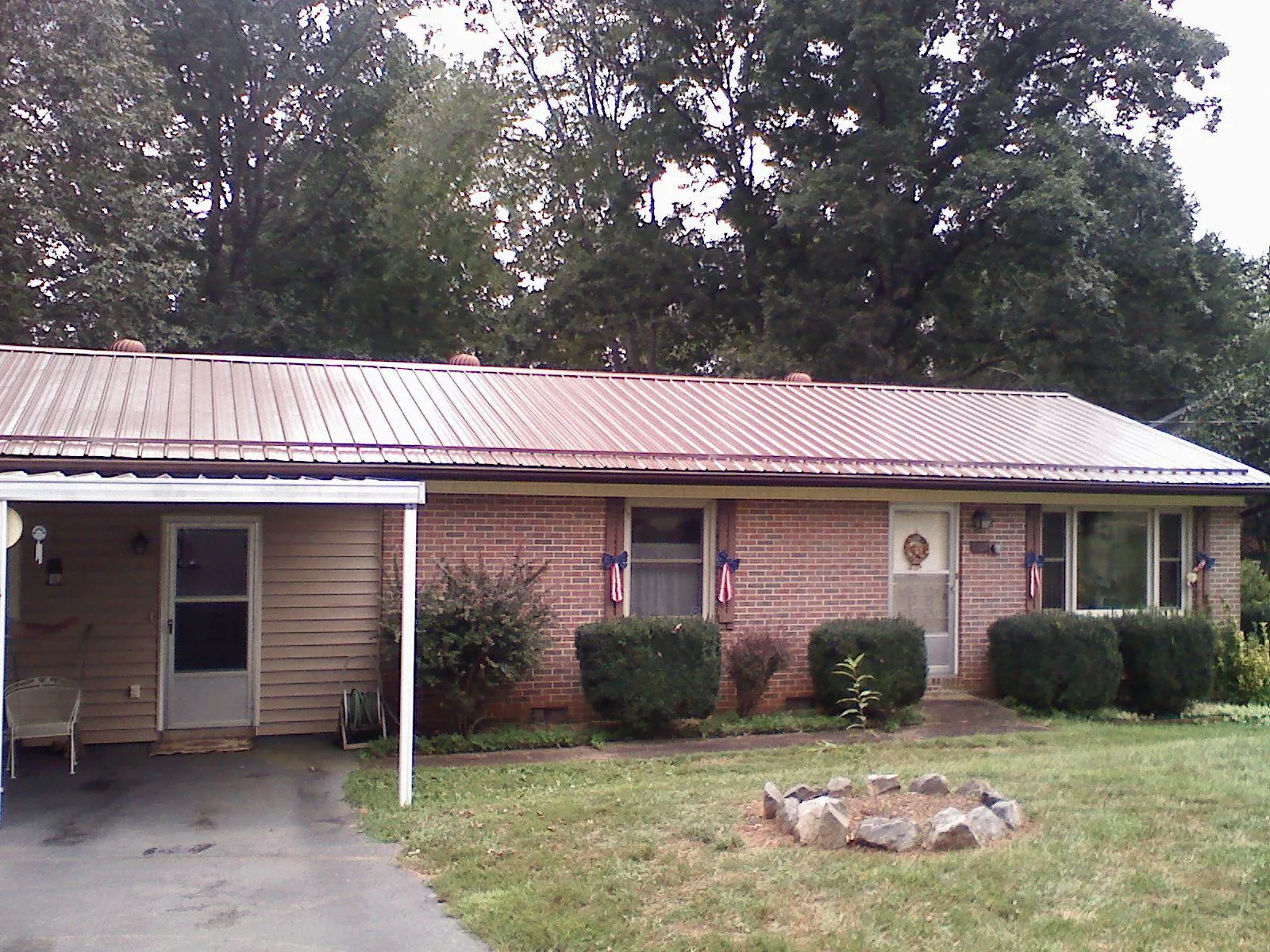 Bronze metal roof and carport on a brick ranch home — Roof Repair work by our crew in Wichita